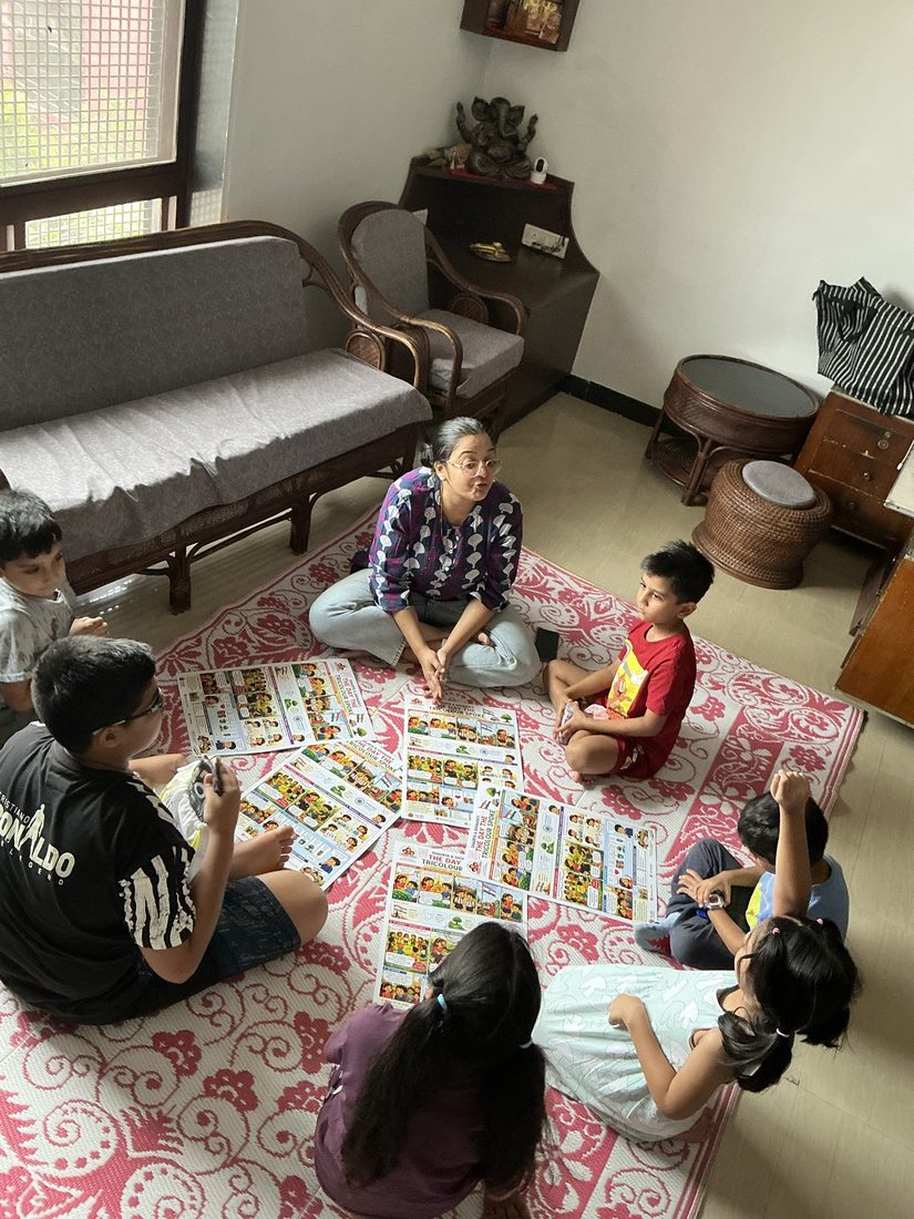 Children sitting in a circle around the charts